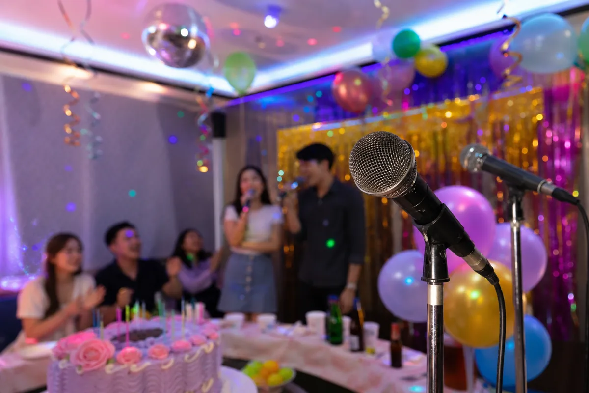 Birthday party karaoke with balloons, cake table and colourful lighting